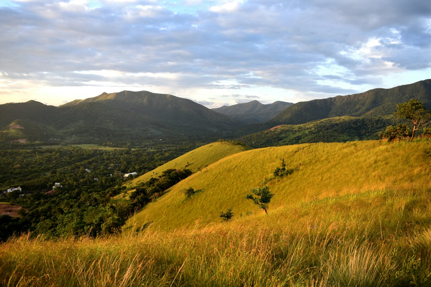 Colline ondulate conducono a una valle lussureggiante e montagne lontane.